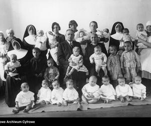 Fotografia grupowa dzieci i opiekunek z fundatorem żłobka Kazimierzem Rosnerem. Widoczna m.in. kierowniczka żłobka pani Sozańska (siedzi obok K. Rosnera); 1921-1939 r.