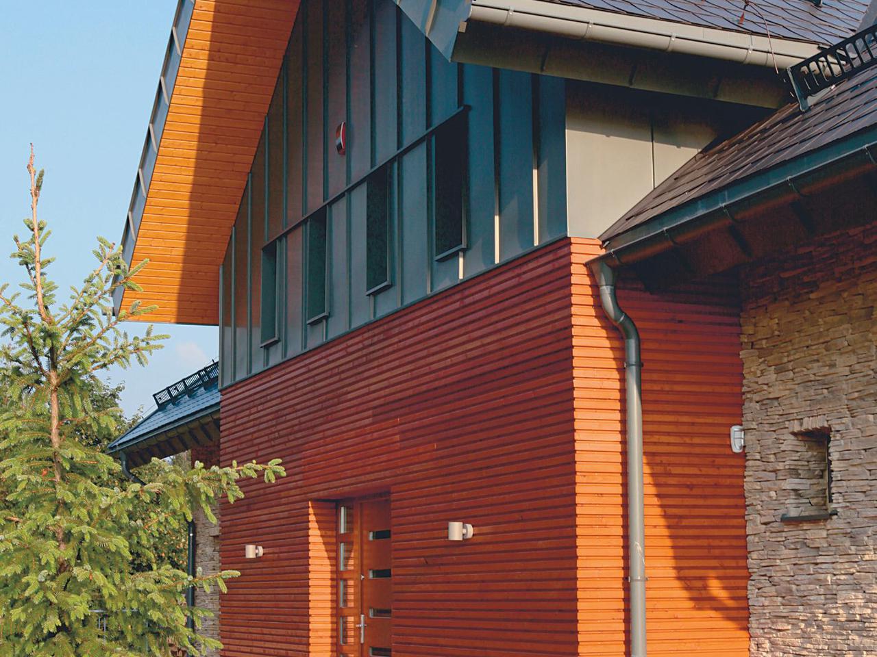 Dom z elewacją z płytek udających piaskowiec i drewnianą szalówką. Ocieplanie ścian i mocowanie płytek elewacyjnych.