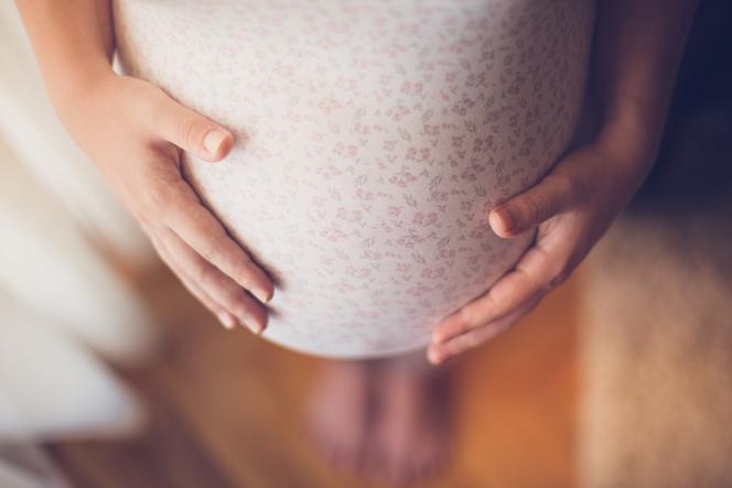 Zbliżenie na brzuch kobiety w ciąży. Czy szczepienia przeciw COVID-19 w ciąży są bezpieczne?