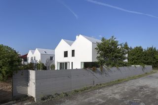 Dwa bliźniaki tworzą miniosiedle, a ich wysokie ściany szczytowe – namiastkę miejskiej pierzei