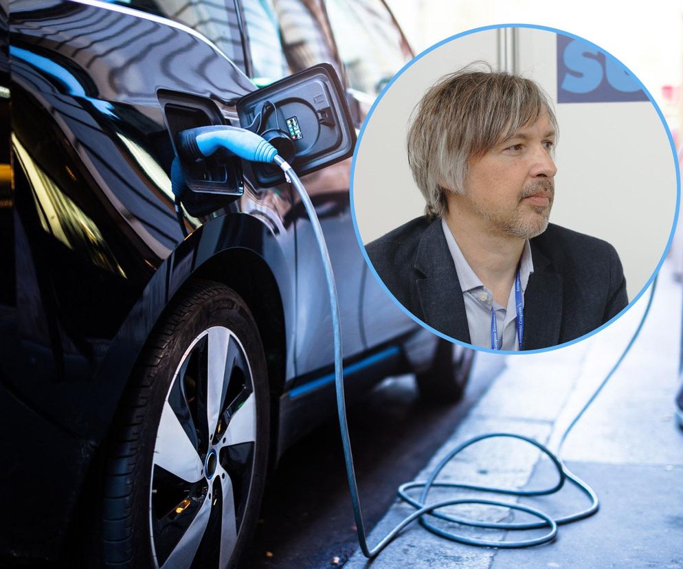 Czarny samochód elektryczny ładowany na stacji ładowania, z wizerunkiem wiceministra klimatu i środowiska Krzysztofa Bolesty obok. Na Super Biznes przeczytasz o zmianach w programie NaszEauto i nowych warunkach dofinansowania.