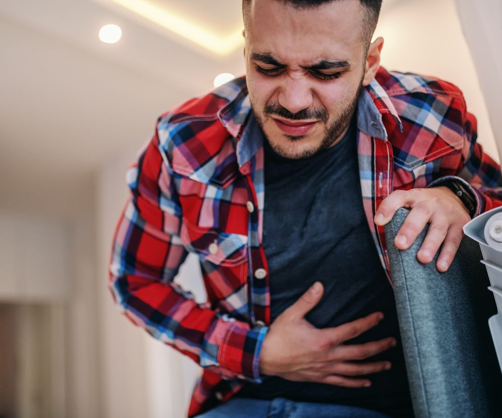 mężczyzna trzymający się za brzuch 