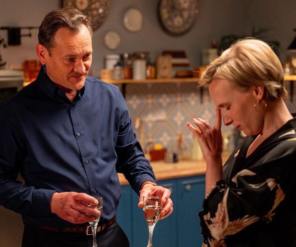 Paweł Ławrynowicz jako Stefaniak, w niebieskiej koszuli, podaje kieliszek szampana Weronice Nockowskiej jako Soni, która trzyma się za głowę. Scena z odcinka serialu Barwy szczęścia dostępnego na Super Seriale, przedstawia intrygę Stefaniaka.