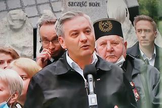 Robert Biedroń na tle religijnego hasła