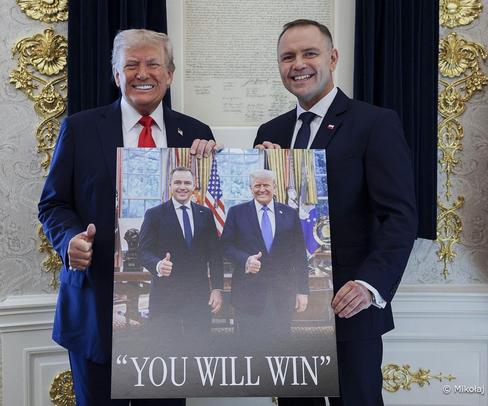 Donald Trump i Karol Nawrocki z uśmiechami trzymają plakat z ich wspólnym zdjęciem i napisem YOU WILL WIN. Scena ma miejsce w pomieszczeniu z amerykańską flagą, co symbolizuje ich polityczne spotkanie, o którym przeczytasz więcej na naszym portalu.