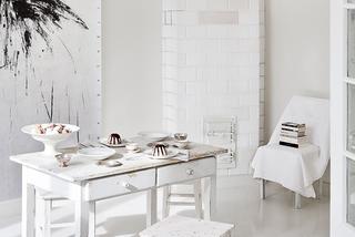 Biały piec kaflowy i stół kuchenny w salonie