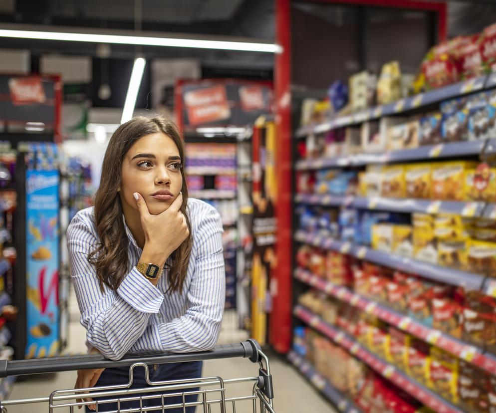 Młoda kobieta w sklepie spożywczym między półkami 