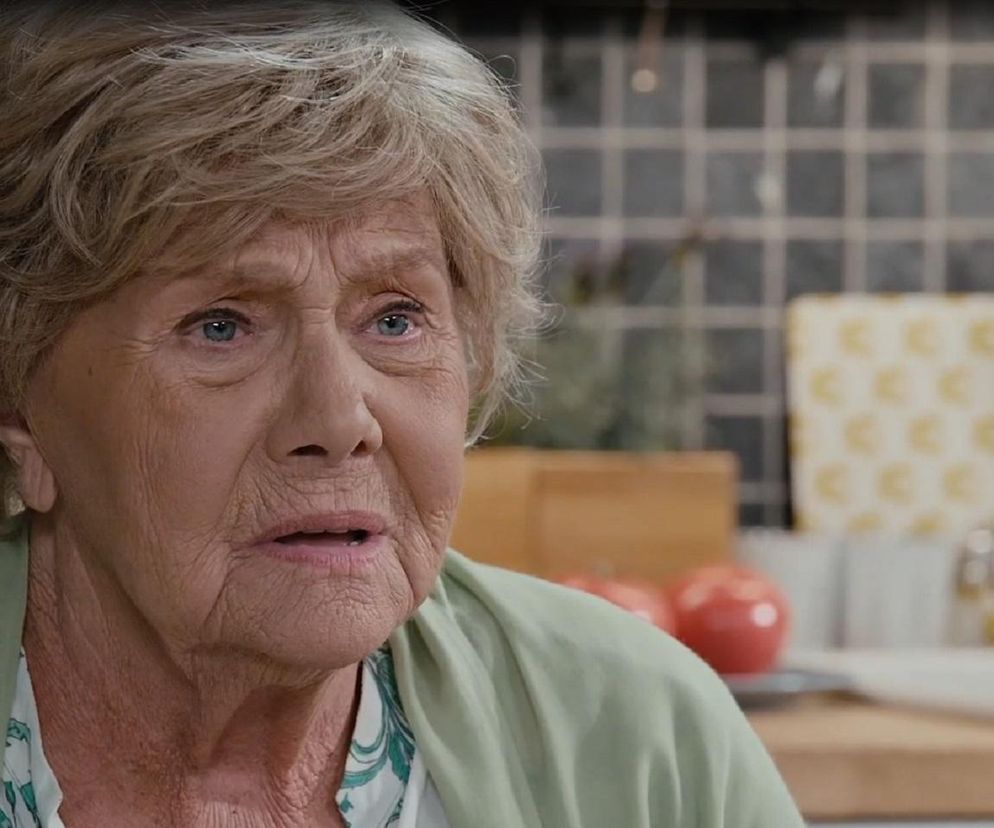 Aktorka Barbara Lipowska w roli Teresy Mostowiak, zmartwiona i zaskoczona decyzją o zdjęciu odcinka M jak miłość z ramówki TVP2, widoczna w kuchni. To zdjęcie ilustruje artykuł o zmianach w emisji serialu na Super Seriale.