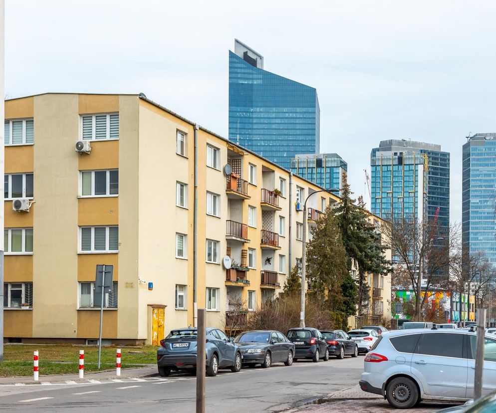 Trzypiętrowy blok przy ulicy Szarych Szeregów 4. W tle nowoczesne wieżowce. O Osiedlu Prototypów przeczytasz w Architektura.