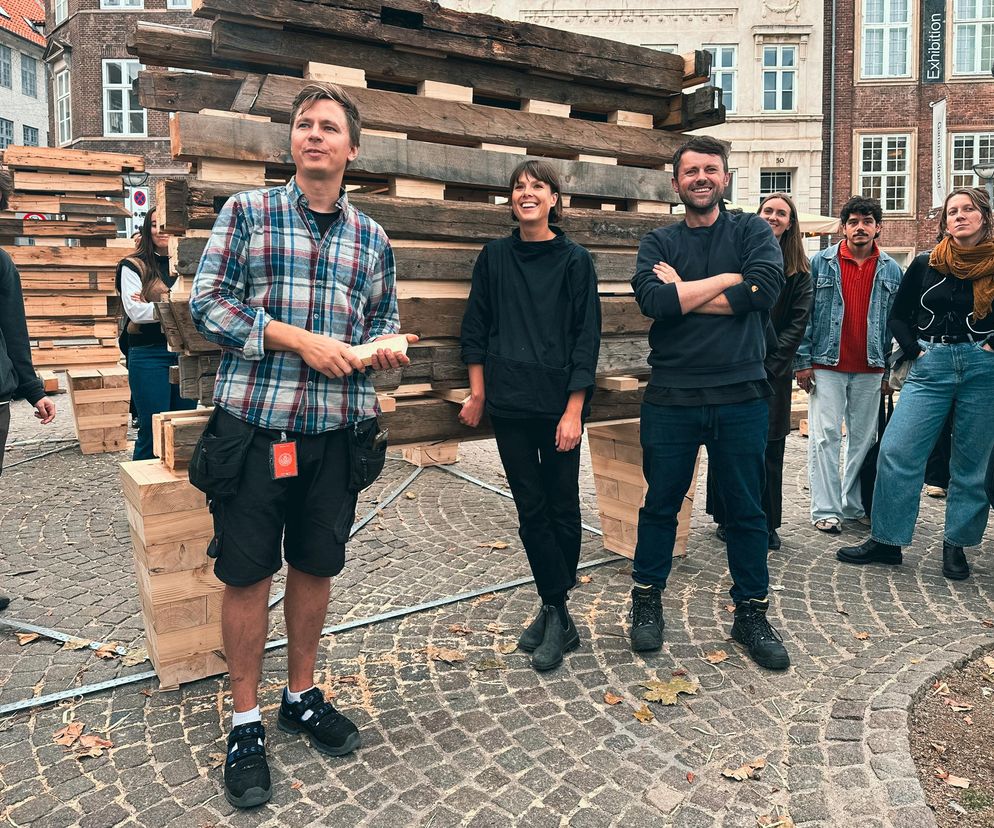 Tom Svilans, Tamsin Hanke i Sash Scott ze studia THISS przed pawilonem Barn Again, stworzonym z odzyskanych drewnianych elementów. Projekt badający życie po życiu budynków, o którym przeczytasz więcej na portalu Architektura Murator Plus.