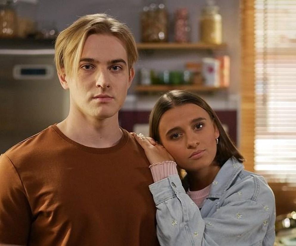 Kamil Biały (Igor Paszczyk) w brązowej koszulce i Angelika (Patrycja Franczak) w różowym swetrze i jeansowej kurtce, opierająca głowę na ramieniu Kamila. Oboje patrzą prosto w obiektyw, symbolizując dylematy uczuciowe, o których przeczytasz więcej na Super Seriale.