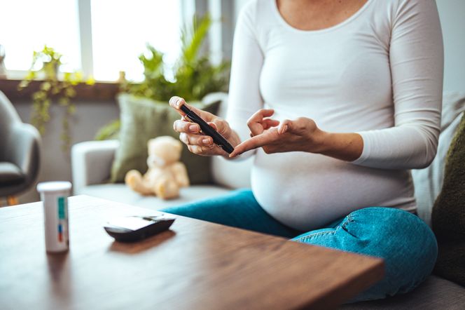 Kobieta w ciąży mierzy sobie poziom cukru glukometrem