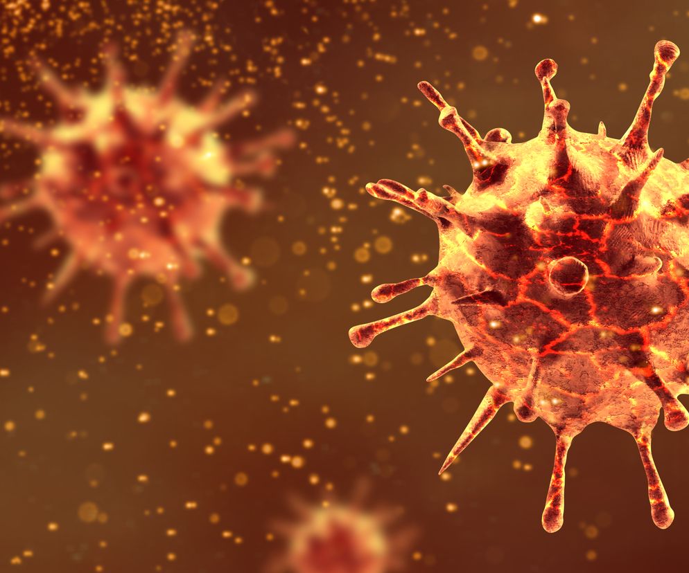 Wizualizacja komputerowa brazylijskiego wariantu koronawirusa P1 w powiększeniu, ukazująca jego strukturę z wypustkami białkowymi, w odcieniach czerwieni i pomarańczu, symbolizując zagrożenie, o którym przeczytasz na portalu Poradnik Zdrowie.