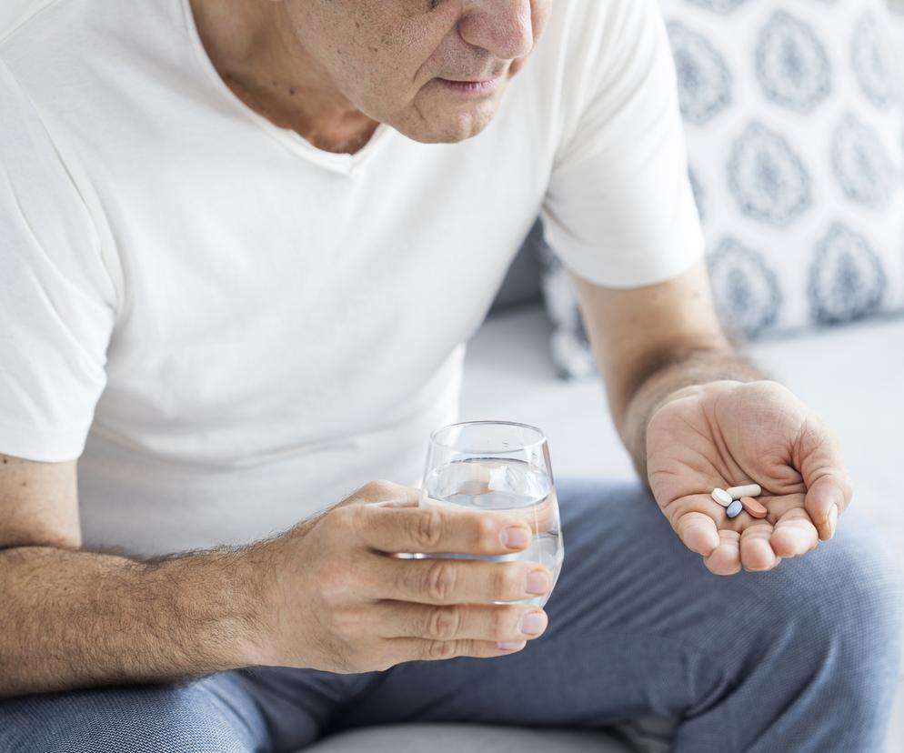 Starszy mężczyzna przyjmuje lek 