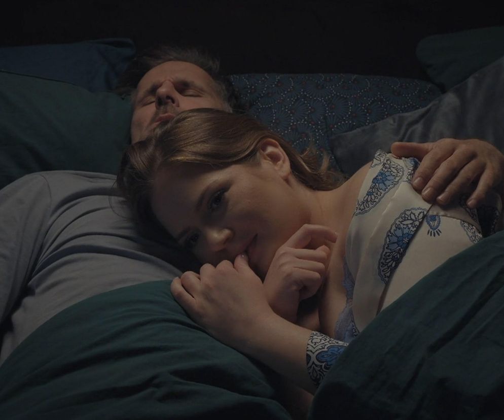 Anita (Melania Grzesiewicz) i Kamil (Marcin Bosak) leżą w łóżku, przytuleni po namiętnych chwilach w 1888 odcinku M jak miłość. Ona opiera głowę na jego ramieniu, patrząc z zamyśleniem, on śpi. Scena z serialu Super Seriale, gdzie para przeżywa wzloty i upadki.