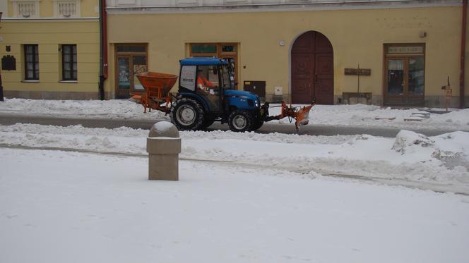 Rynek w Tarnowie pod śniegiem. W akcji pługopiaskarka MPGK