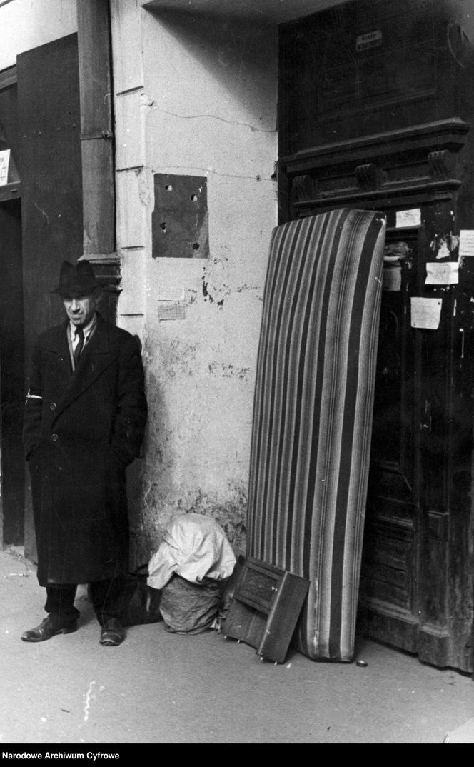 Przesiedlanie Żydów do getta. Żyd ze swoim dobytkiem stoi przed kamienicą, Warszawa 1939