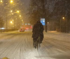 Śnieg sparaliżował ulice miasta, a rowerzysta próbuje jechać środkiem drogi [NAGRANIE]