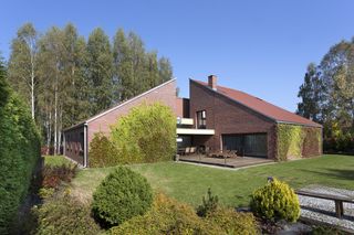 Dom 3x1 ma w sobie coś ze starej zagrody wiejskiej. Jego współczesny charakter podkreślają detale: brak okapu dachów, spore okna oraz płaskie płaszczyzny ścian