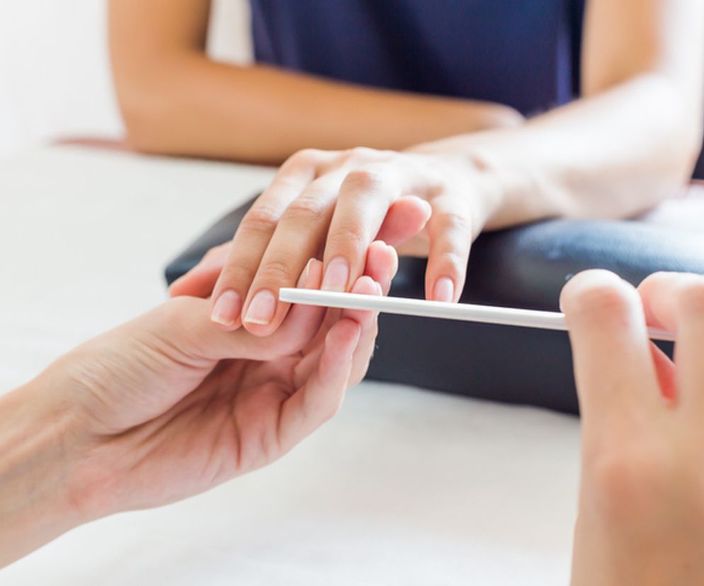 Stylistka paznokci wykonująca manicure