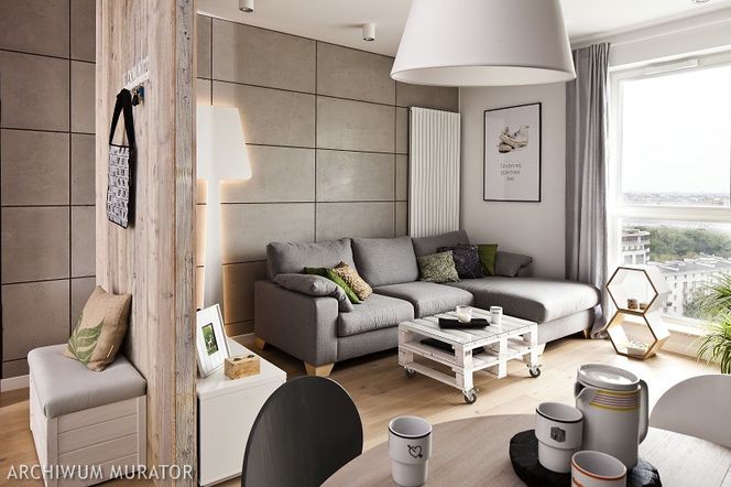 Męska aranżacja salonu: drewno i beton w dekoarcji wnętrza