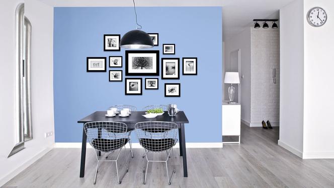 Błękitna ściana w jadalni wykończona na biało