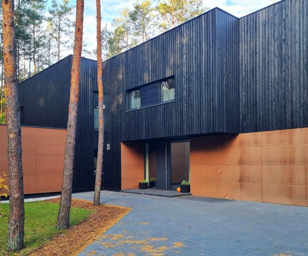 Nowoczesny Dom Mchów architekta Mirosława Jednacza, o elewacji z opalanych desek modrzewiowych i miedzianych panelach, wtapiający się w leśne otoczenie w warszawskim Międzylesiu. Projekt zgłoszony do konkursu Życie w Architekturze 2025, o którym więcej przeczytasz na Architektura Murator Plus.