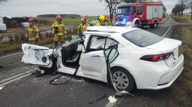 Tragiczny wypadek pod Lesznem. Przód osobówki został kompletnie zmiażdżony. Strażacy wycinali z wraku poszkodowaną