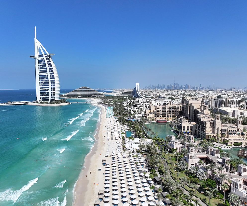 Hotel Burdż al-Arab w Dubaju przy plaży z parasolami. O ostrzeżeniach MSZ dla podróżnych przeczytasz na Eska.