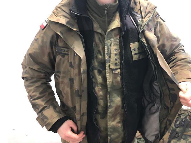 Żołnierz pokazuje, ile warstw odzieży ma pod kurtką
