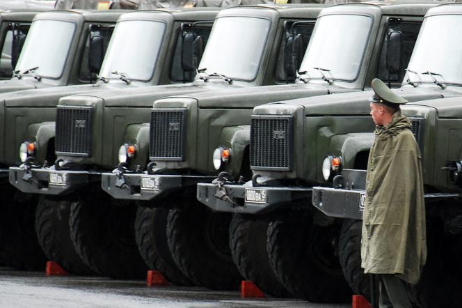 Rosyjski żołnierz na tle ciężarówek