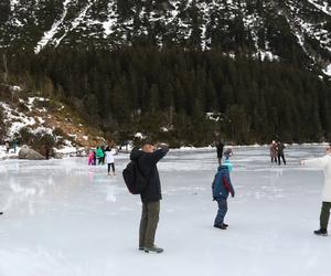 Tatry, 26.12.2022. Turyści na tafli lodu na jeziorze Morskie Oko w Tatrach