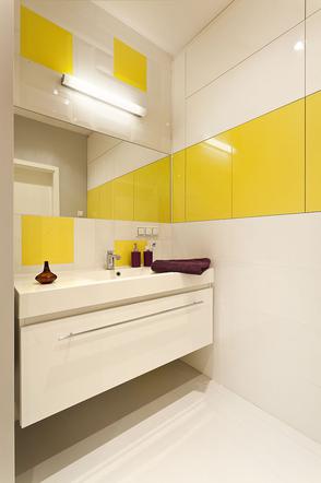 Żółte drzwi szafek w białej łazience