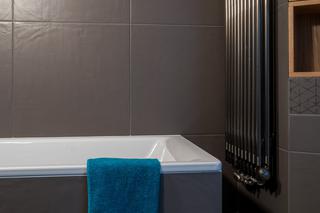 Żeberkowy grzejnik wskazuje na styl industrialny łazienki