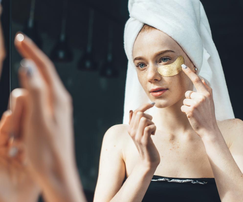 Kobieta przed lustrem robi okłady pod oczy