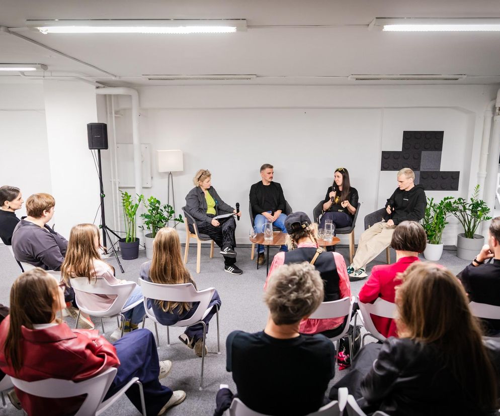 Uczestnicy debaty „Życie na własnych zasadach” w Aptece Designu, siedzący na scenie przed publicznością. Widoczni paneliści: Ola Zając, Julian Madej, Jacek Peszko, dyskutują o rezygnacji z nadmiaru. Więcej o wydarzeniach takich jak ta debata przeczytasz na portalu Architektura Murator Plus.