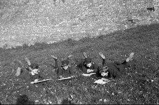 Chłopcy przeglądający książki na trawie przed murami Wawelu (1928 r.)