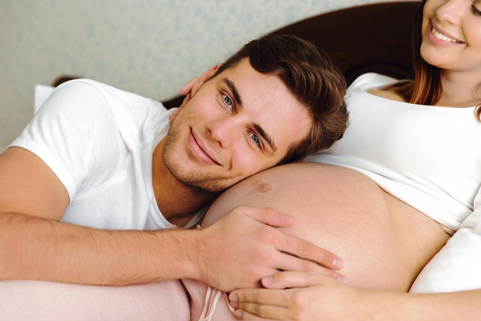 Беременная женщина лежит с мужем