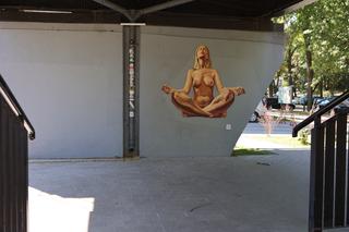 Naga kobieta uprawia jogę. Street art Lubliun