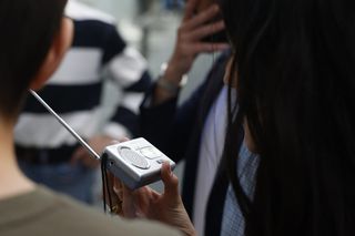 Kobieta słucha radia na baterię w czasie blackoutu w Madrycie