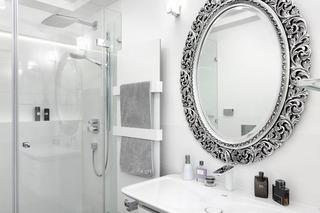 Biała łazienka z dekoracyjnym lustrem