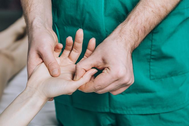 Ortopeda bada dłonie kobiety