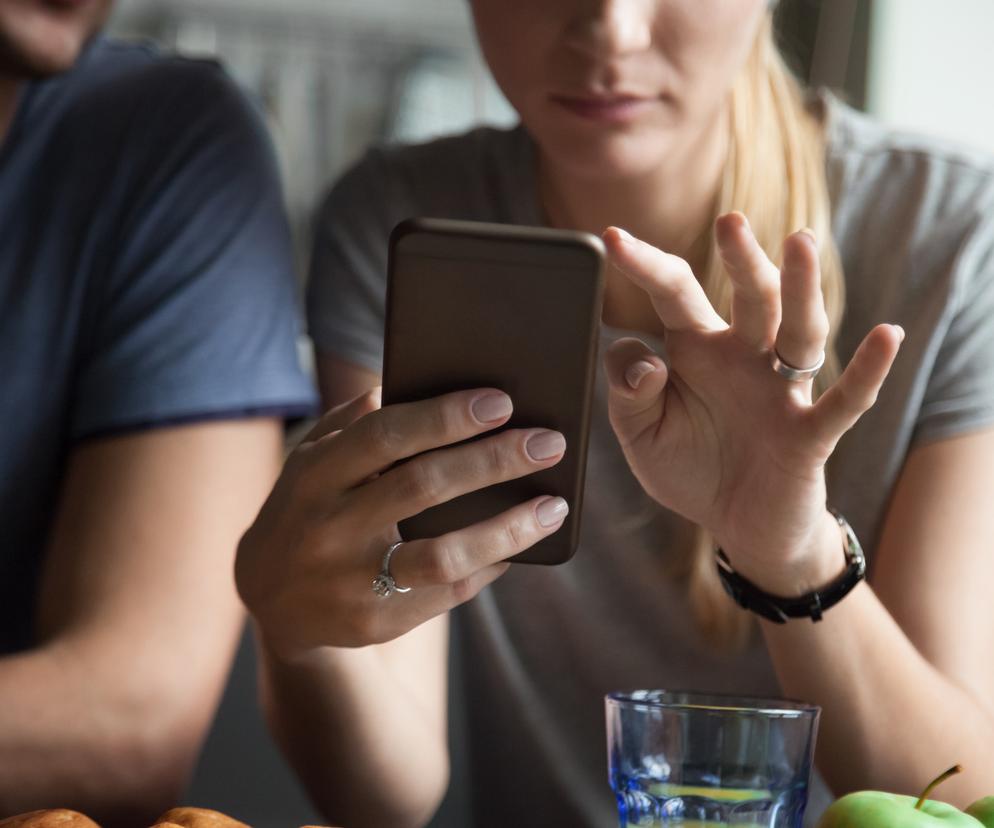 Zbliżenie na kobietę, która trzyma w dłoni smartfon