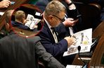 W  czasie obrad Sejmu poseł przeglądał katalog z bronią