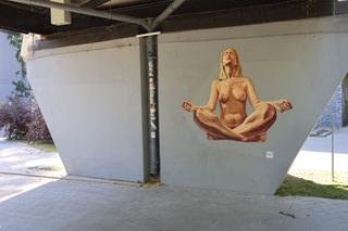 Naga kobieta uprawia jogę. Street art Lubliun