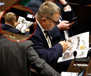 W  czasie obrad Sejmu poseł przeglądał katalog z bronią