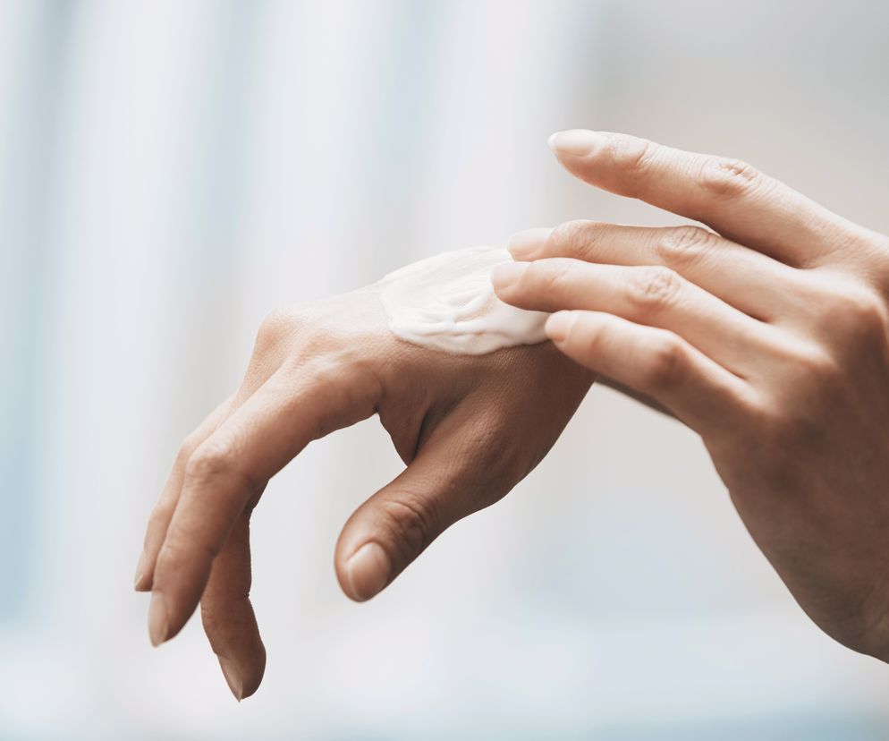 Kobieta nakłada krem ​​nawilżający na dłonie