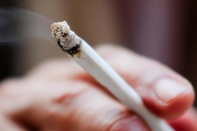 zbliżenie na papierosa trzymanego w męskiej dłoni