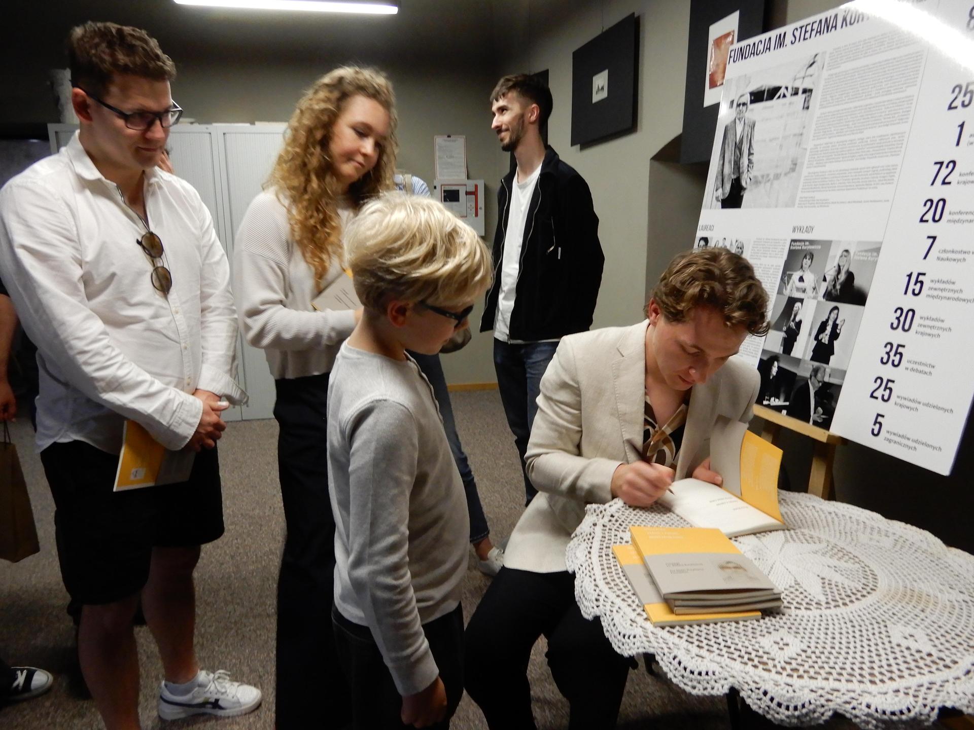 Maciej Rodak podpisuje swoją książkę 