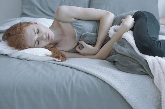 Nastolatka trzymająca się za brzuch z powodu bólu menstruacyjnego 